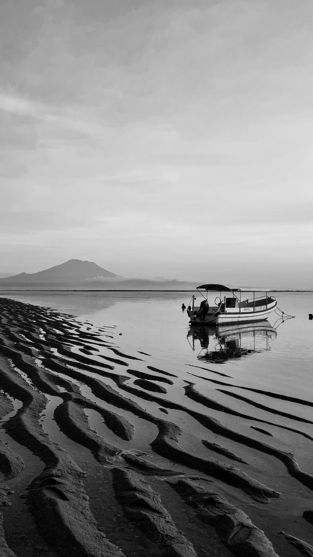 a boat sitting on top of a beach next to the ocean