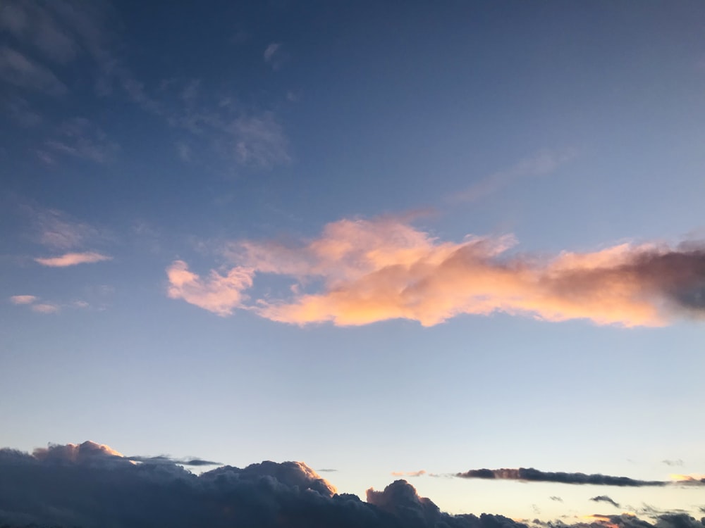 a plane flying in the sky at sunset