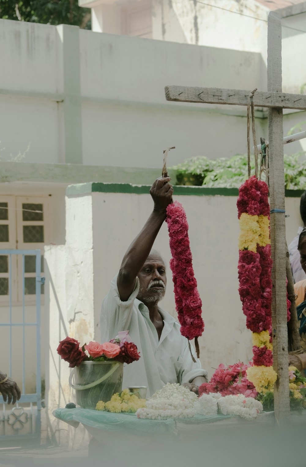 a man is holding up a flower arrangement