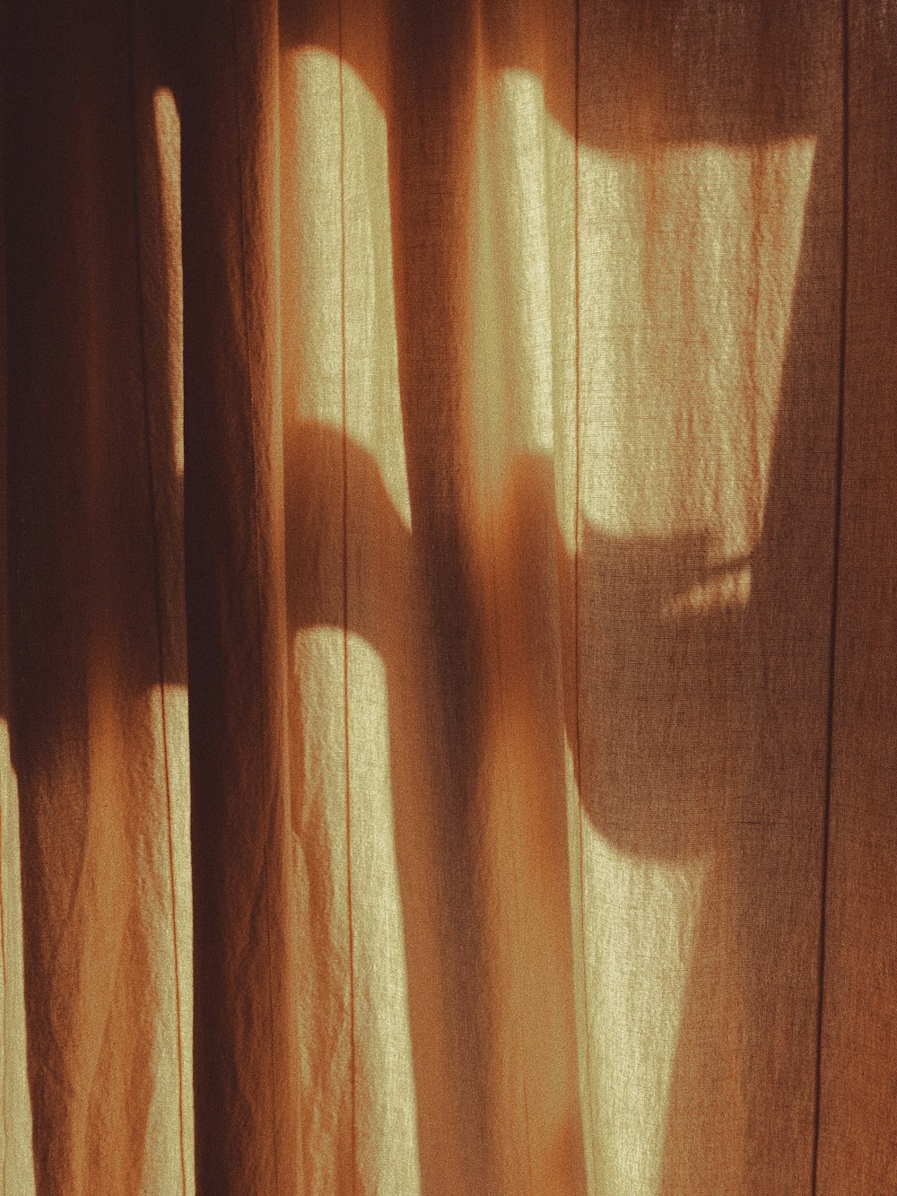 Ein Schatten der Hand einer Person auf einem Vorhang
