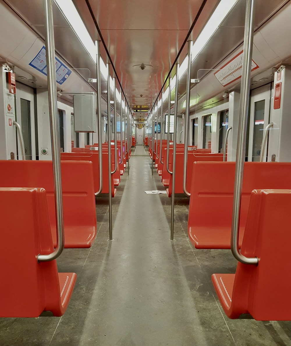 a long empty train car with red seats