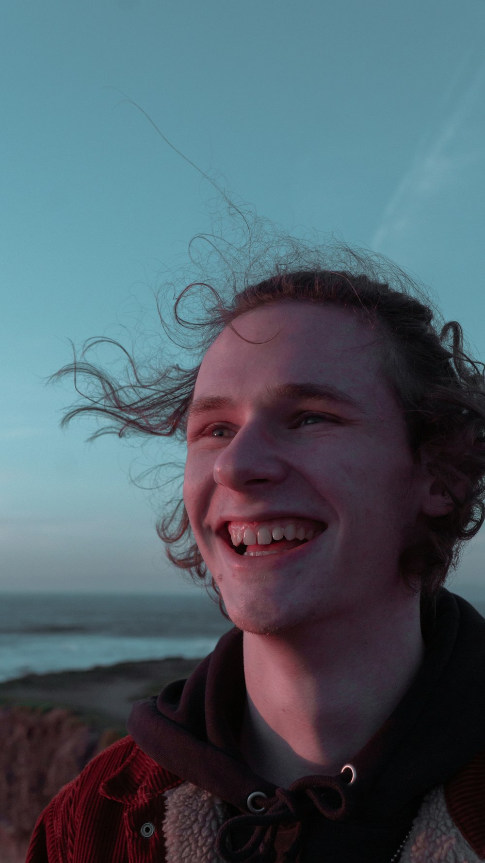 Un hombre con el pelo largo sonriendo a la cámara