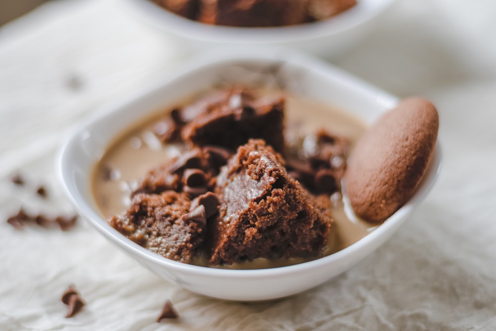 a white bowl filled with brownies and a cookie