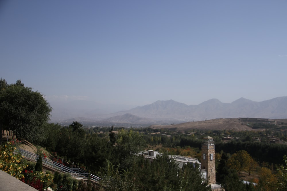 a view of a mountain range with a clock tower in the foreground