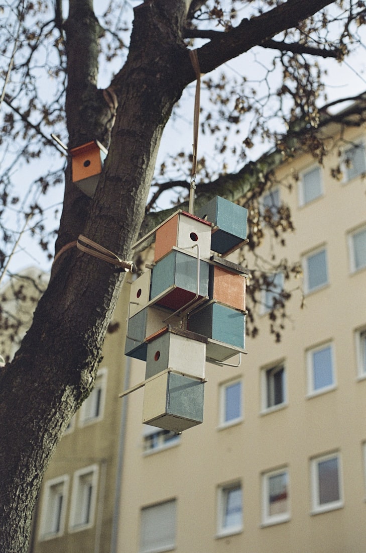 A colorful stacked cluster of small geometric cube-form birdhouses.