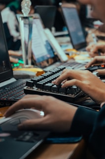 a person typing on a keyboard in front of a laptop