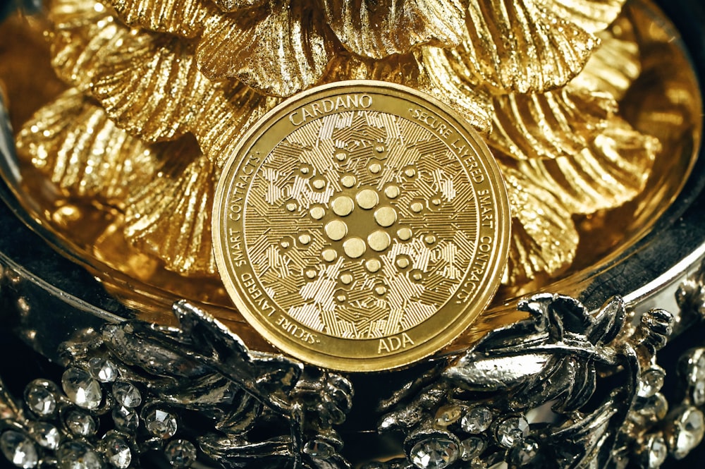a gold coin sitting on top of a pile of silver chains