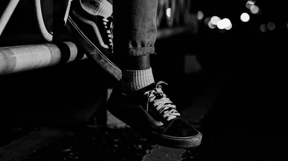 a black and white photo of a person wearing sneakers