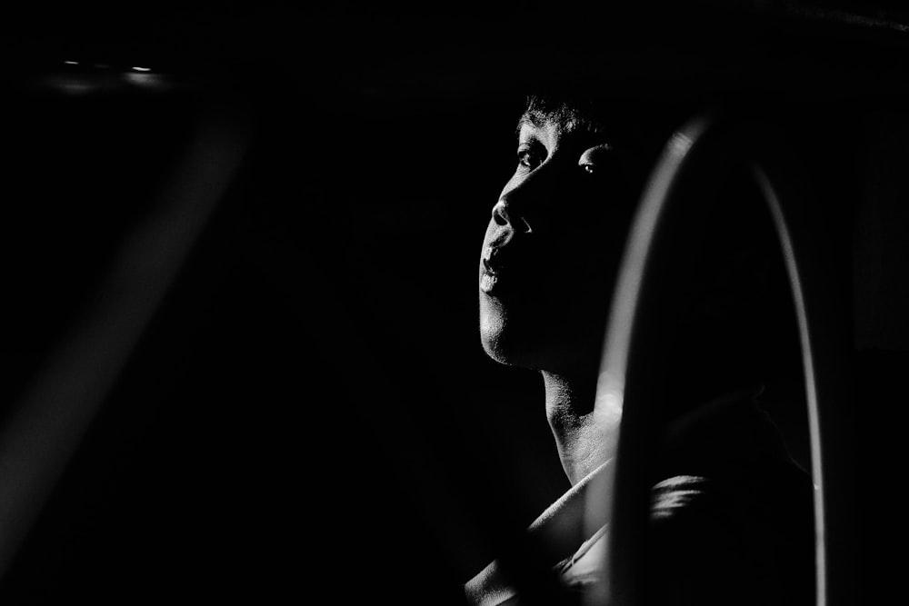 a black and white photo of a man driving a car