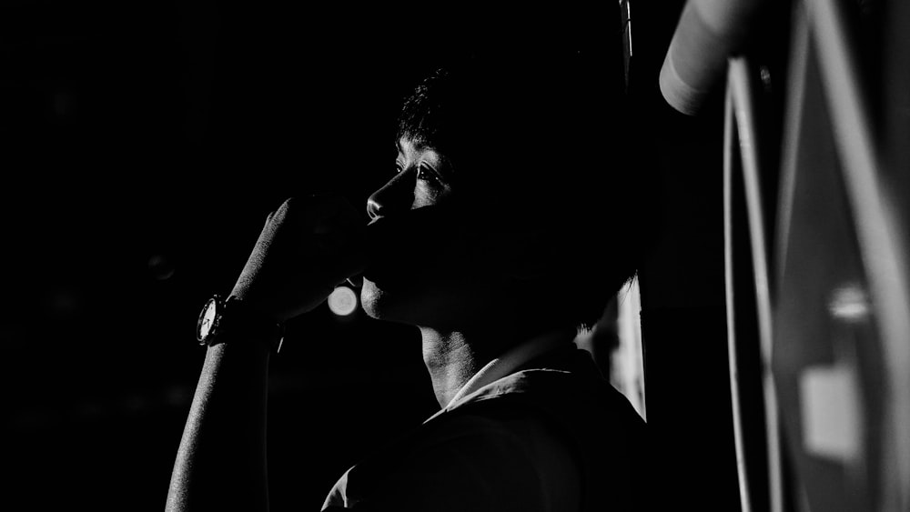 a black and white photo of a man talking on a cell phone