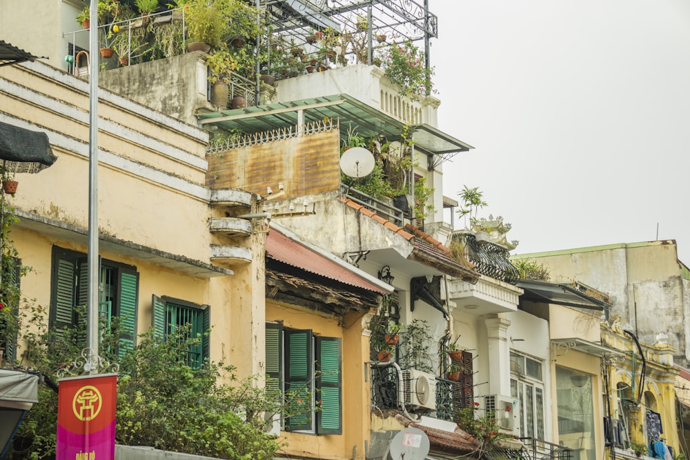 a row of buildings with balconies and green shutters