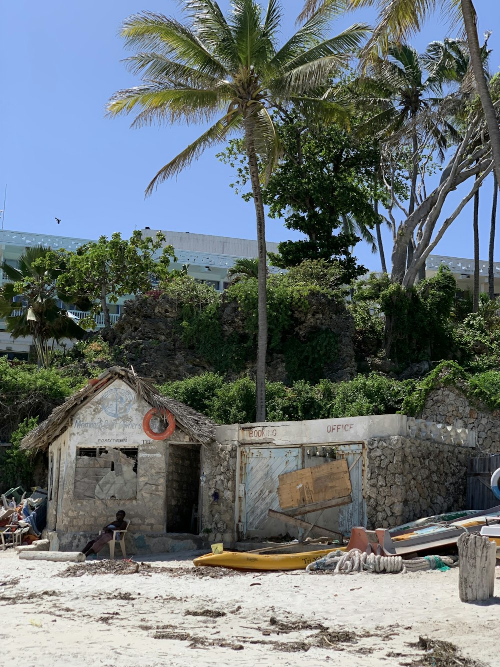 a hut on a beach with palm trees in the background