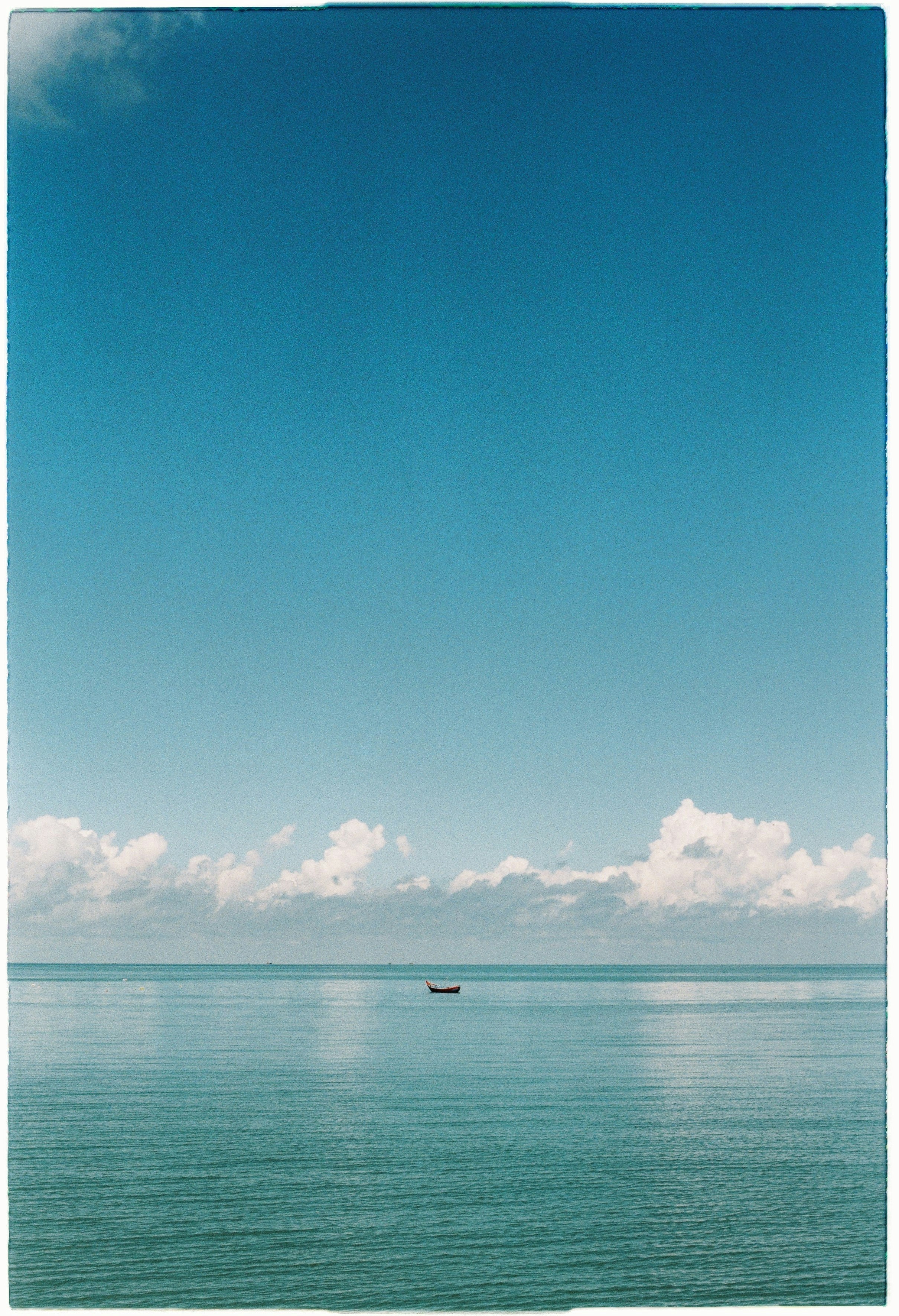 a lone boat floating in the middle of a large body of water