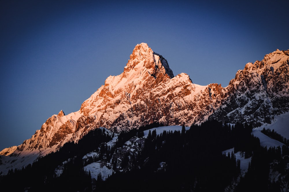 a snow covered mountain with a blue sky in the background