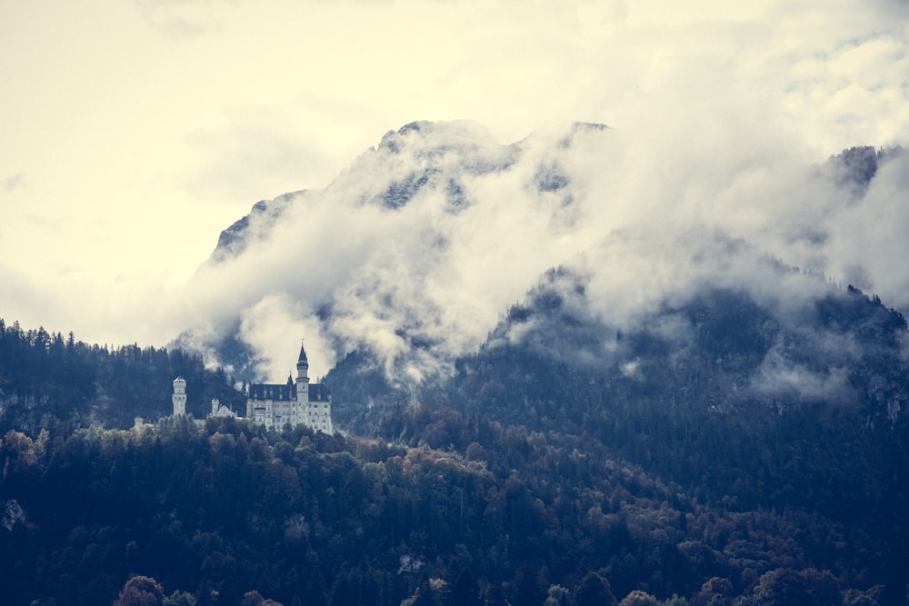 Un castillo en medio de una montaña rodeado de nubes