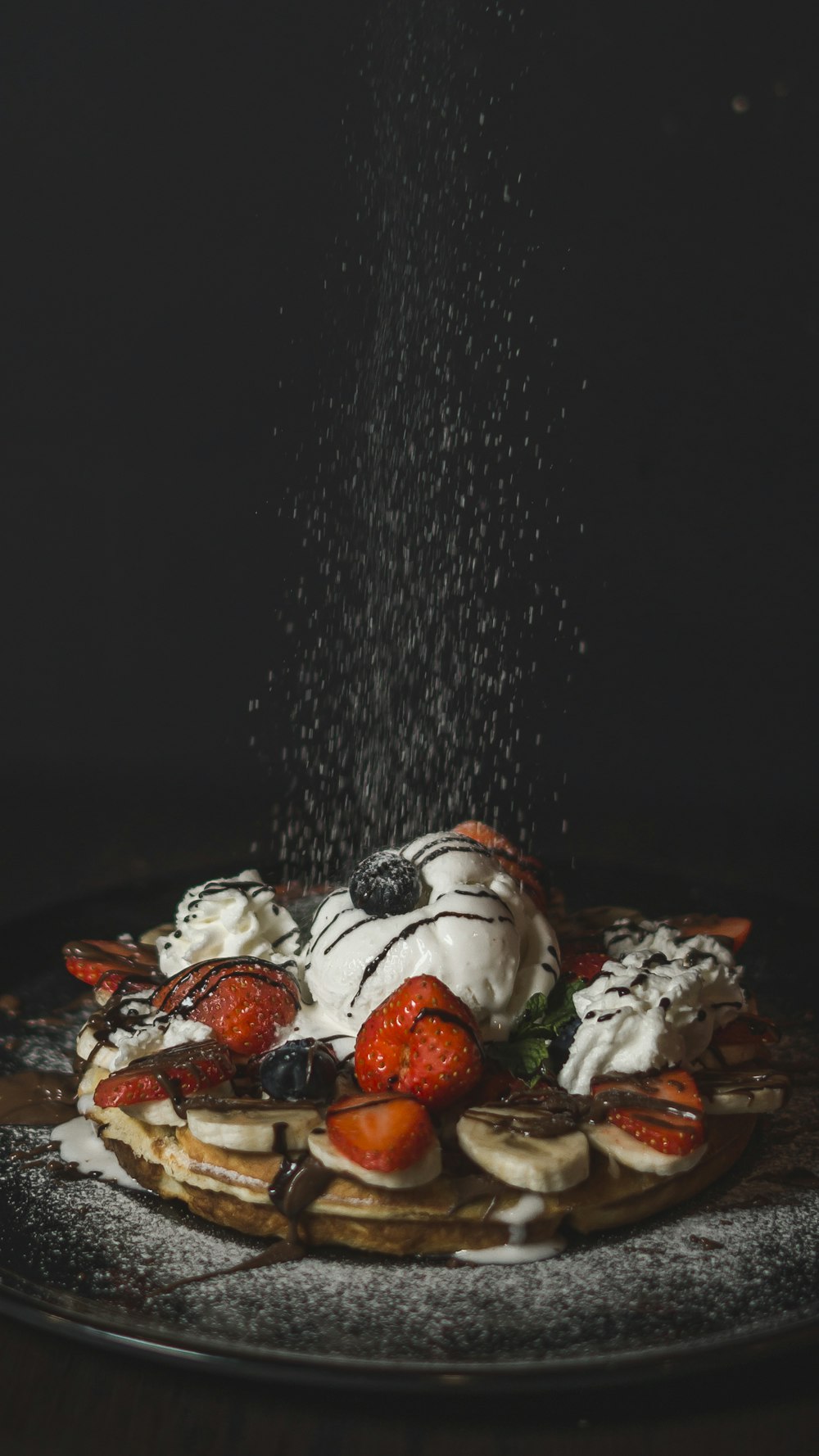 a waffle topped with whipped cream and fruit