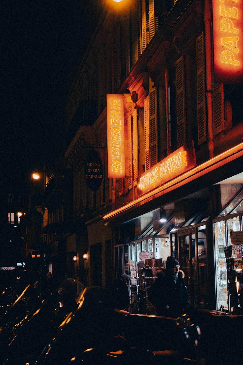 a dark city street at night with neon signs