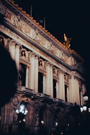 Illuminated Parisian building at night, elegant and mysterious atmosphere in the heart of Paris