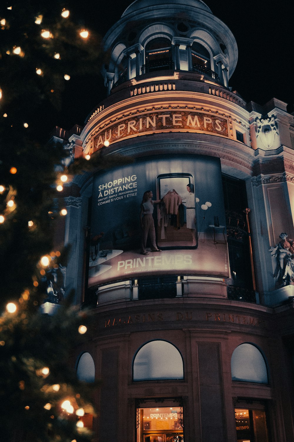 a tall building with a christmas tree in front of it