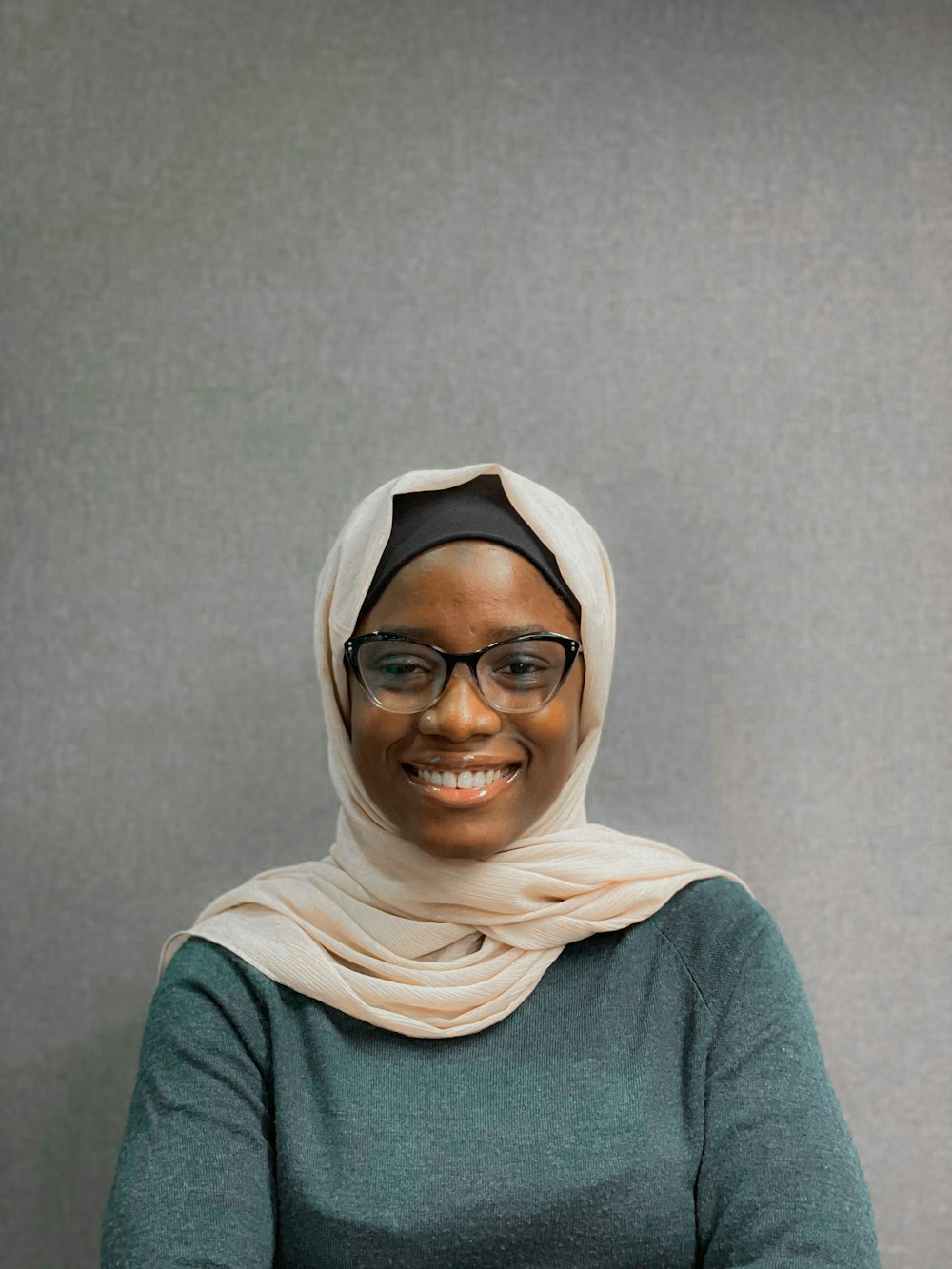 a woman in a headscarf smiles for the camera