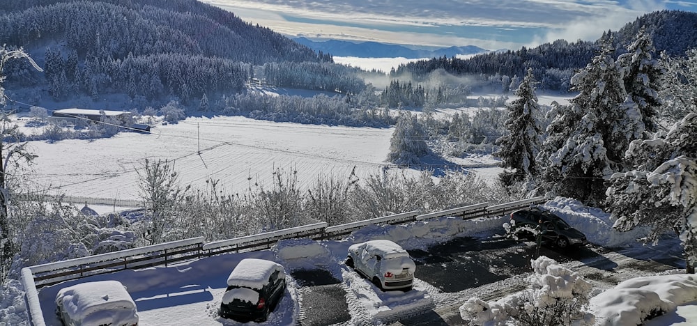 uma vista de uma montanha coberta de neve com carros estacionados na neve