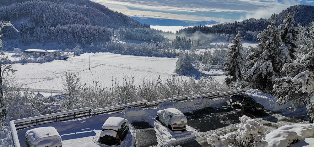 a view of a snow covered mountain with cars parked in the snow