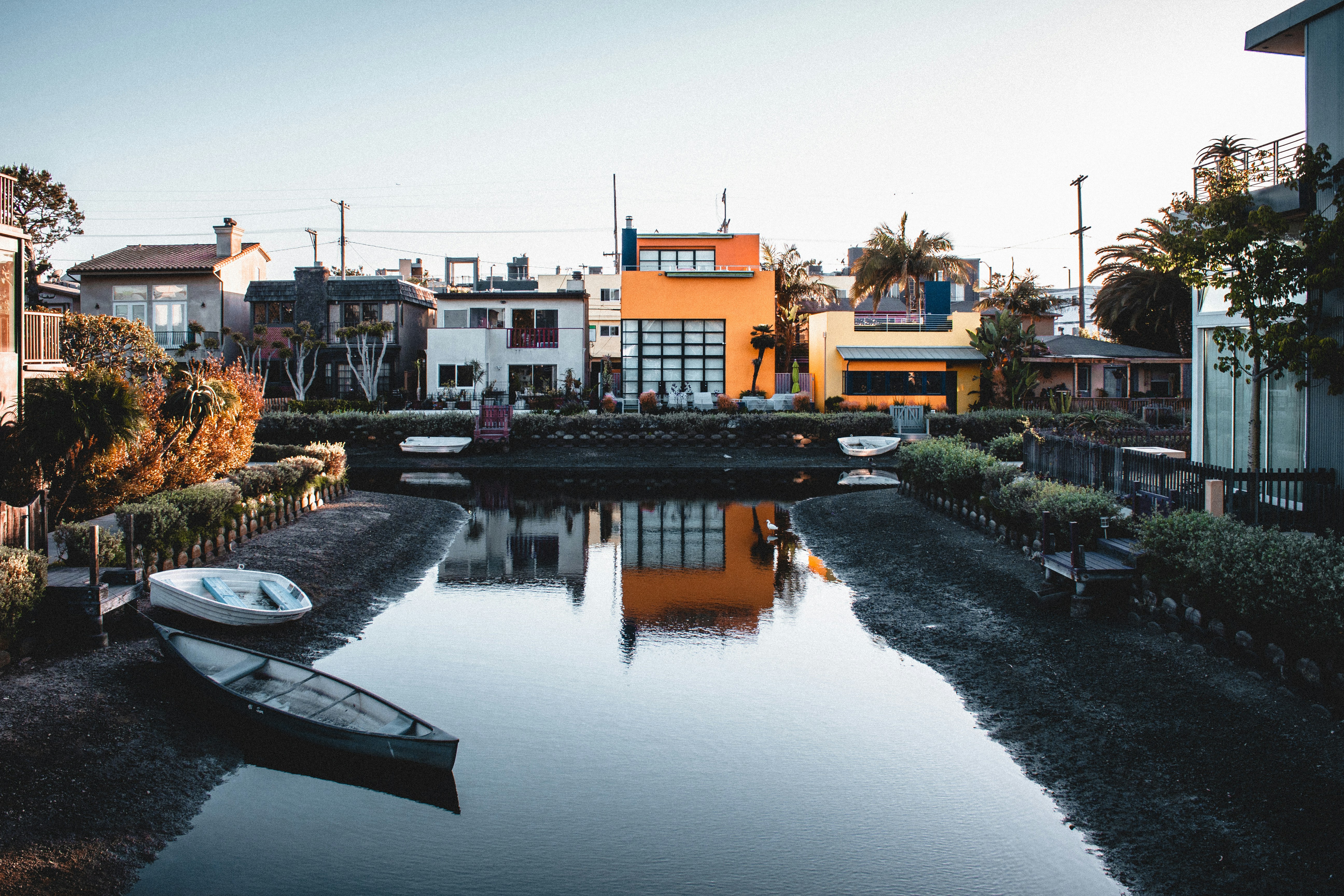 a body of water with a boat in the middle of it, A nice little house in the Venice area of Los Angeles.