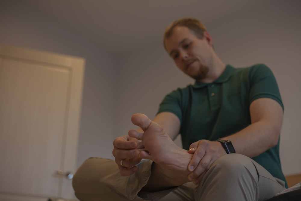 a man sitting on a bed with his feet up