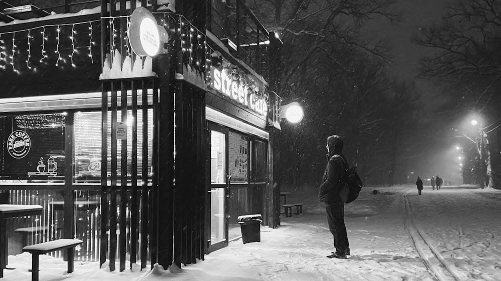 a person standing on a snowy street at night