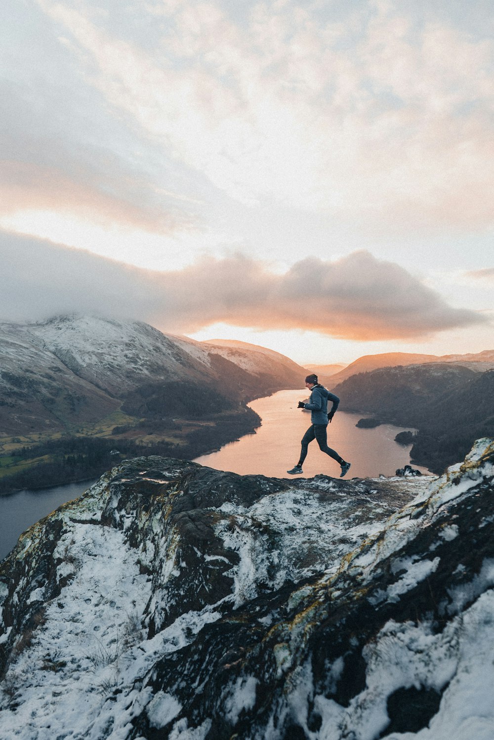 a man running up the side of a snow covered mountain