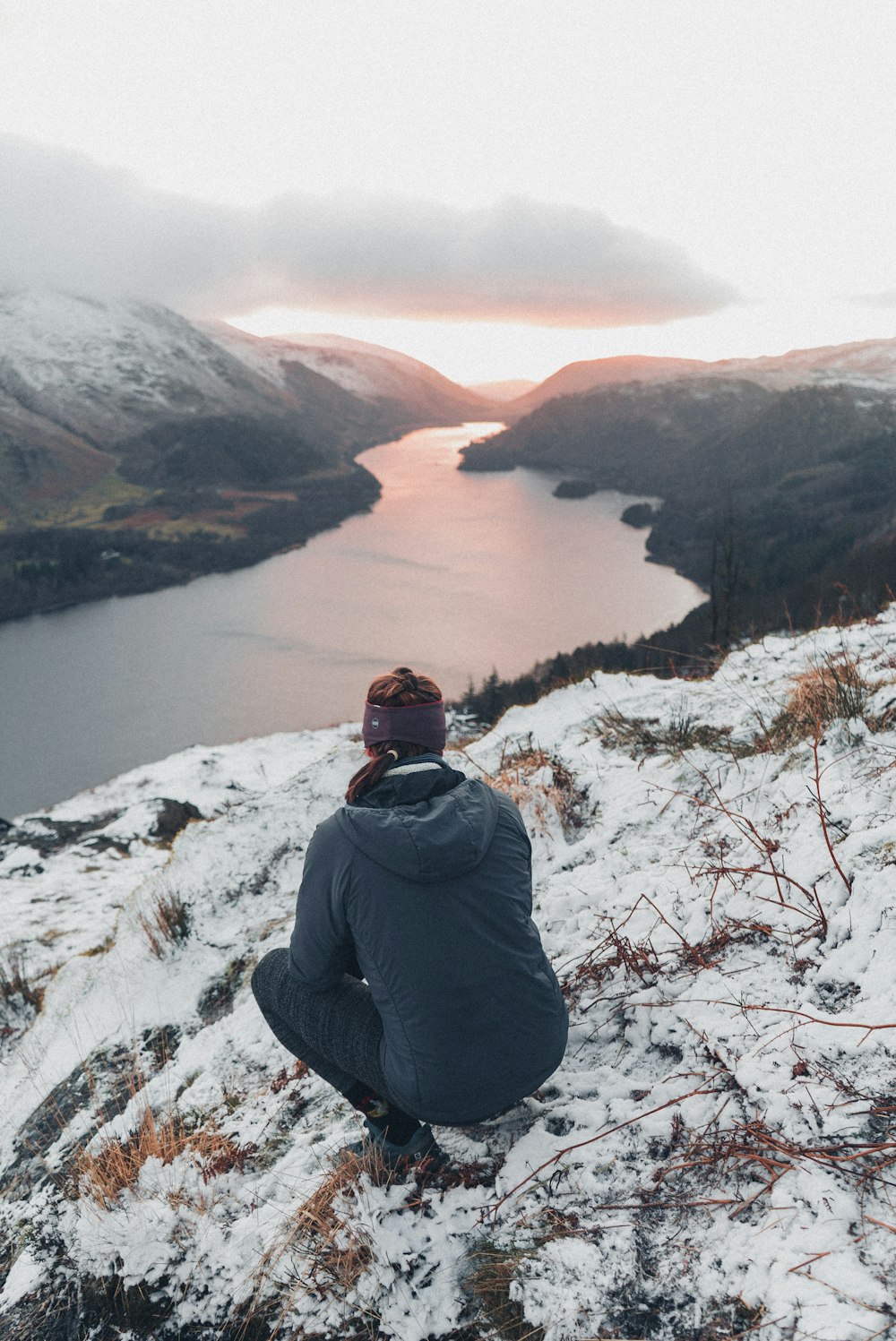 a person sitting on top of a snow covered hill