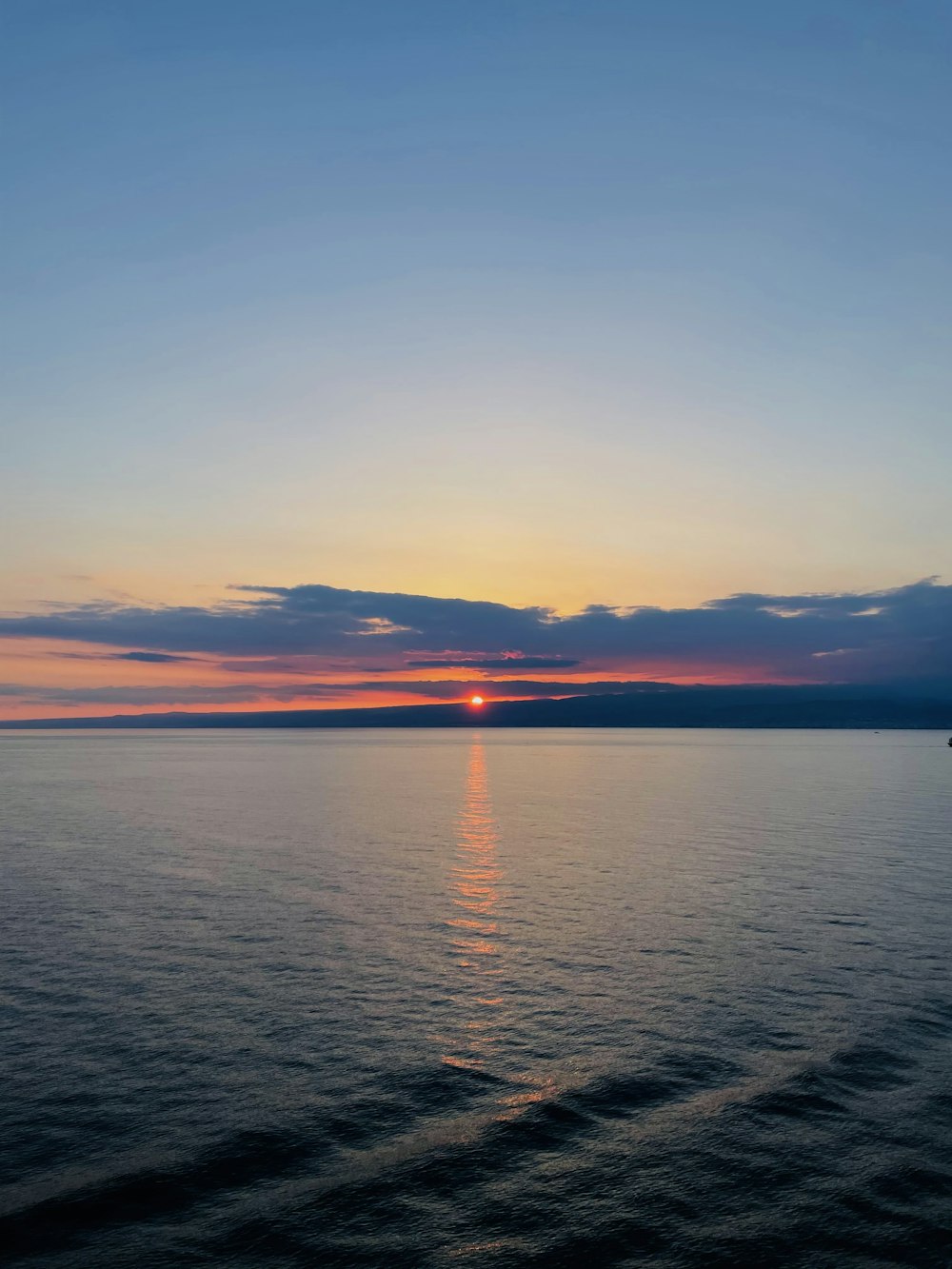 the sun is setting over the ocean on a clear day