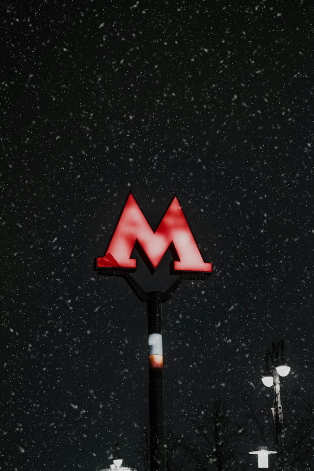 a red m sign sitting on the side of a building