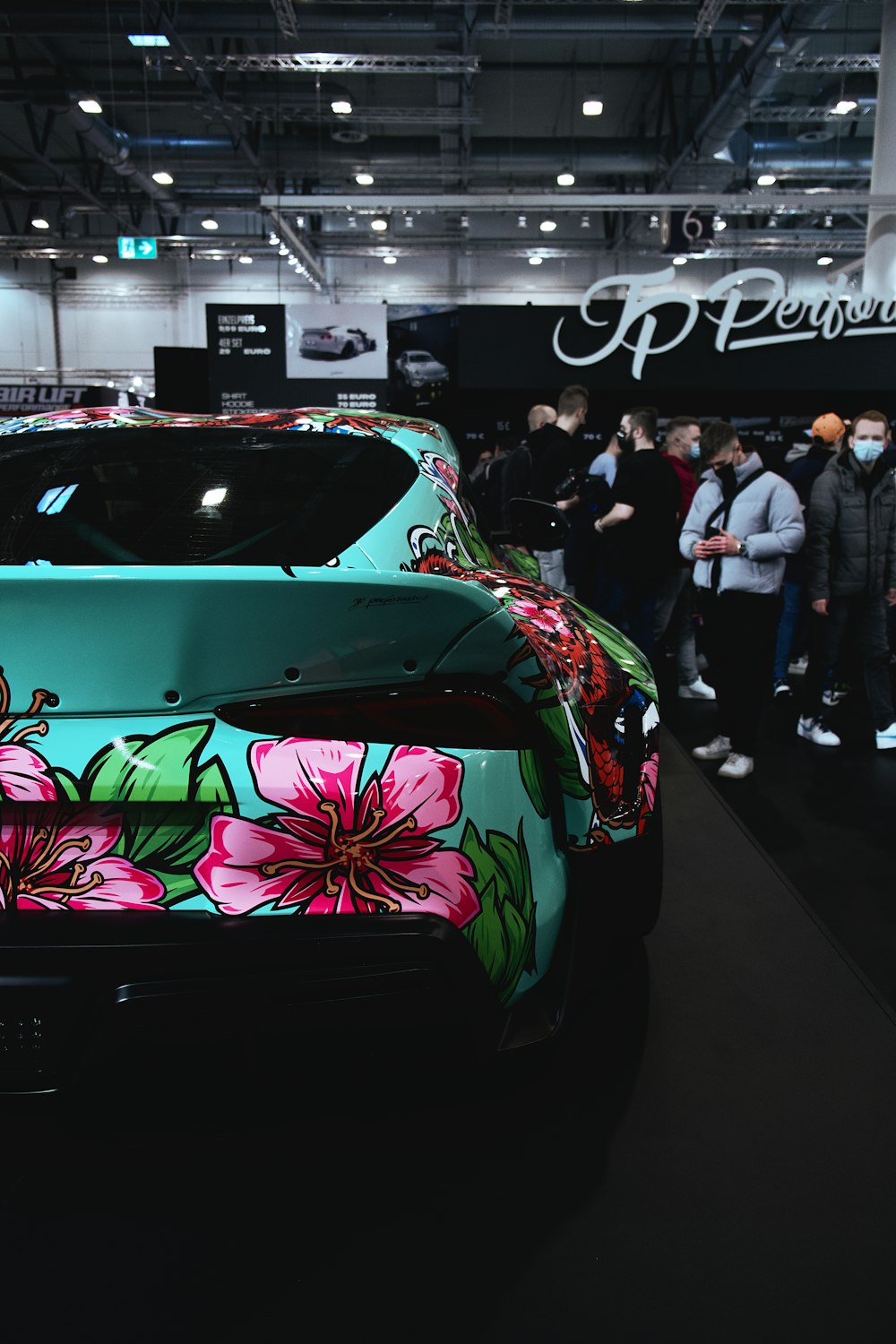 a green sports car with flowers painted on it