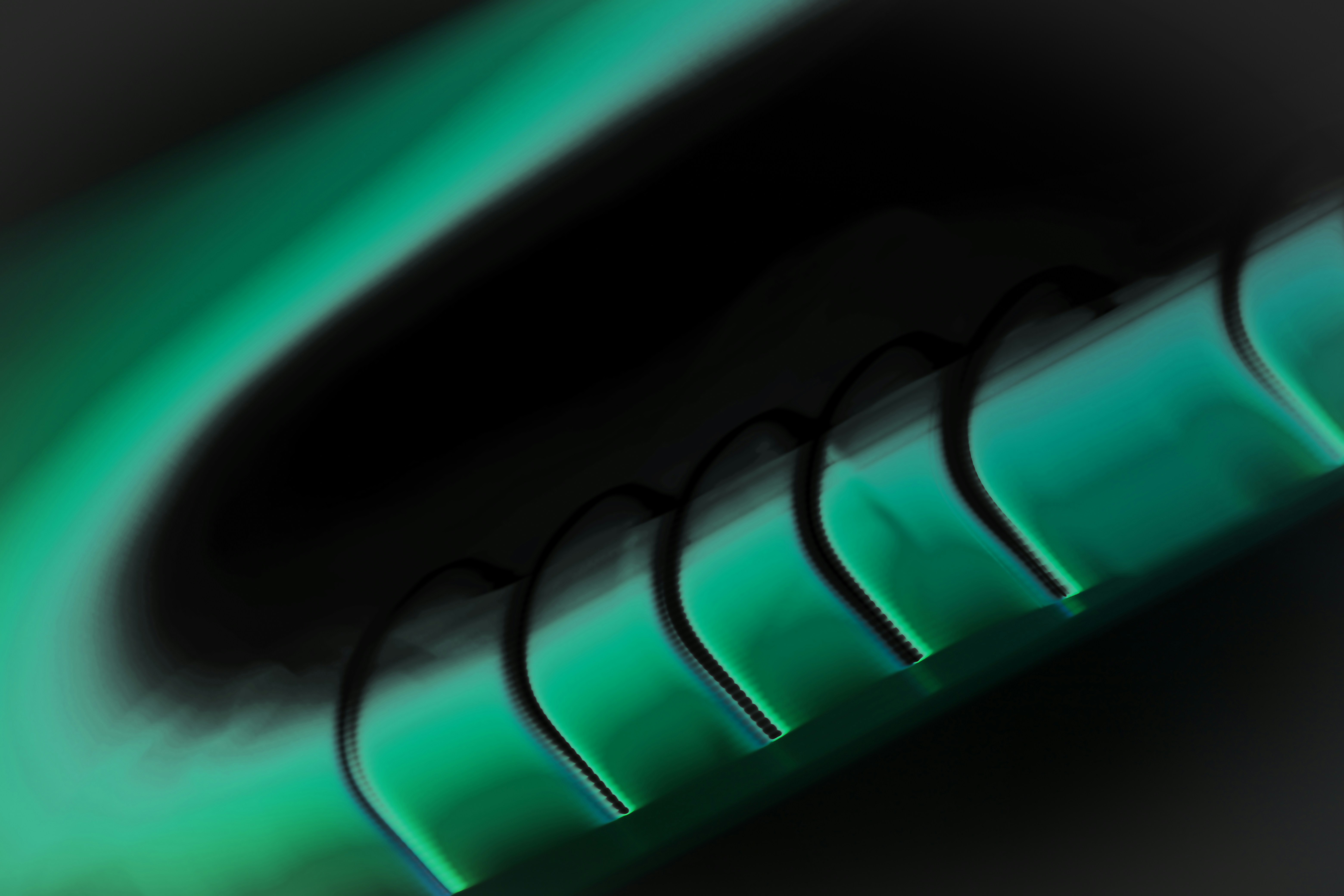 a close up of a green toothbrush with a black background