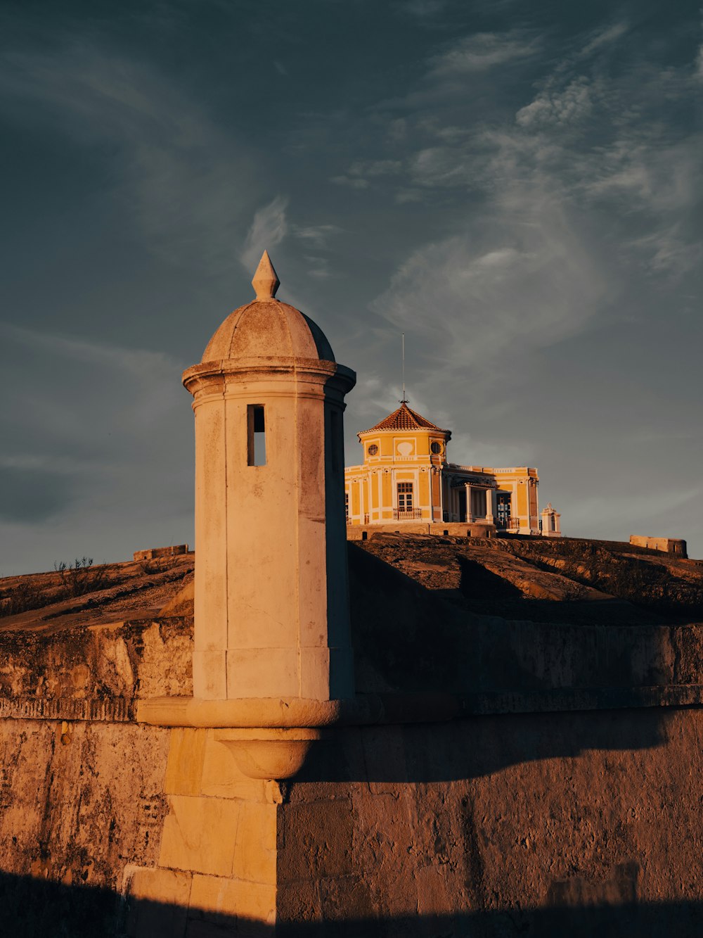 a building on top of a hill with a sky background