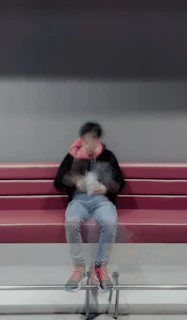 a person sitting on a bench with a cell phone