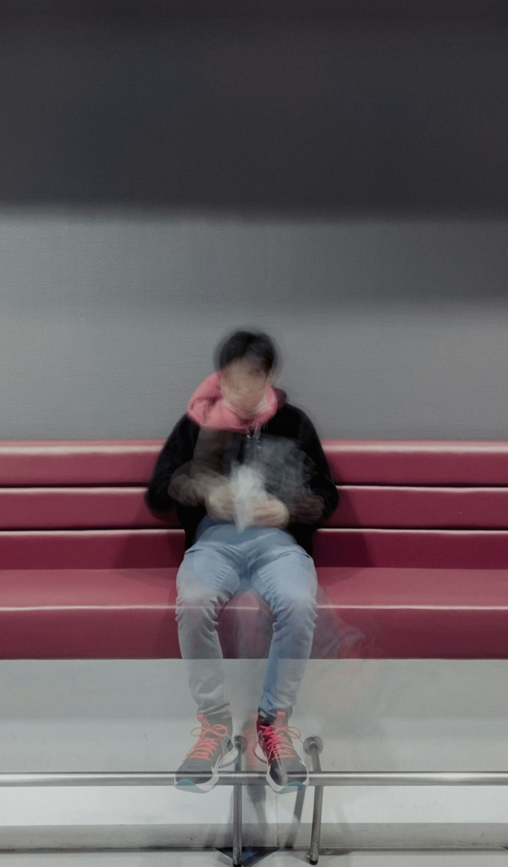 a person sitting on a bench with a cell phone