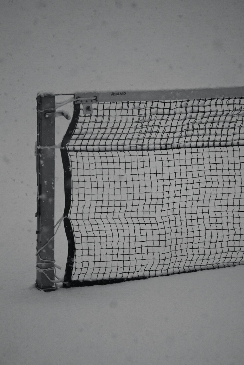 a black and white photo of a net in the snow