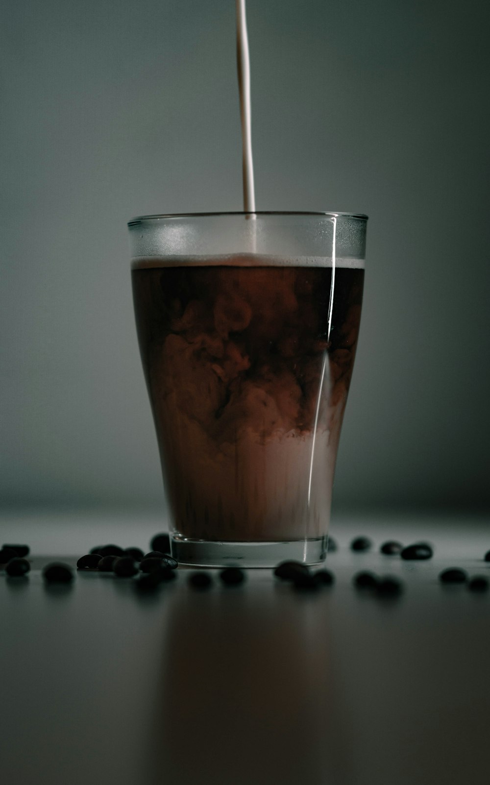 a glass filled with liquid sitting on top of a table