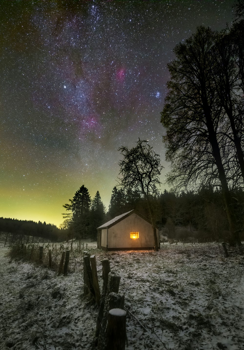 a barn in the middle of a snowy field