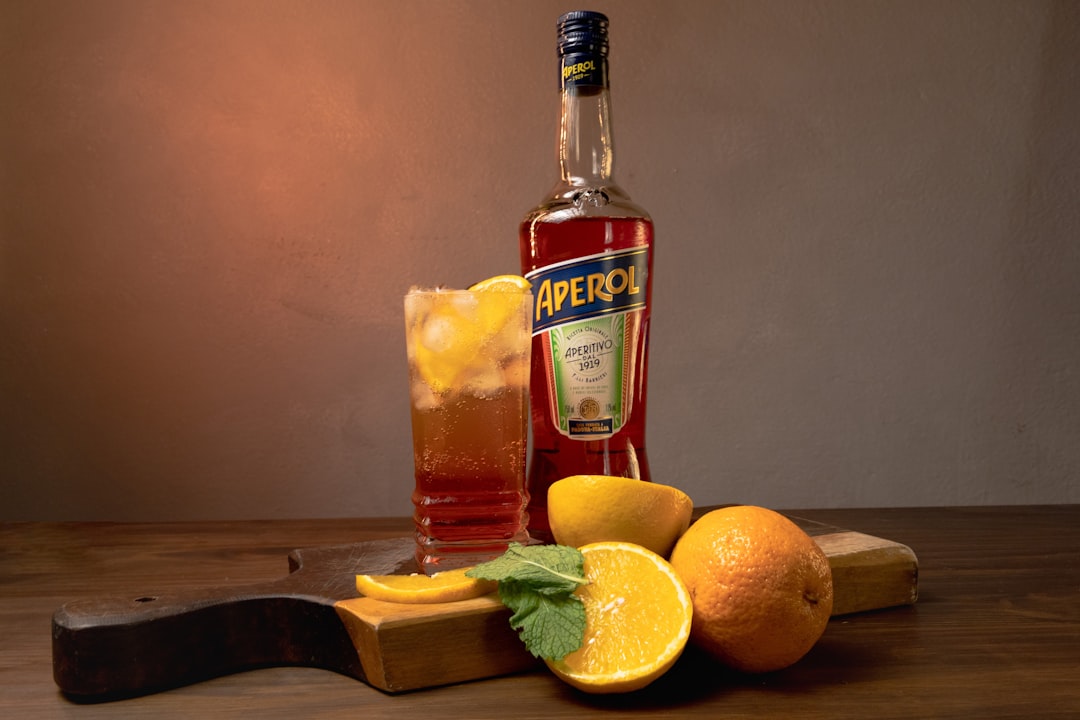 a bottle of alcohol sitting on top of a wooden cutting board,