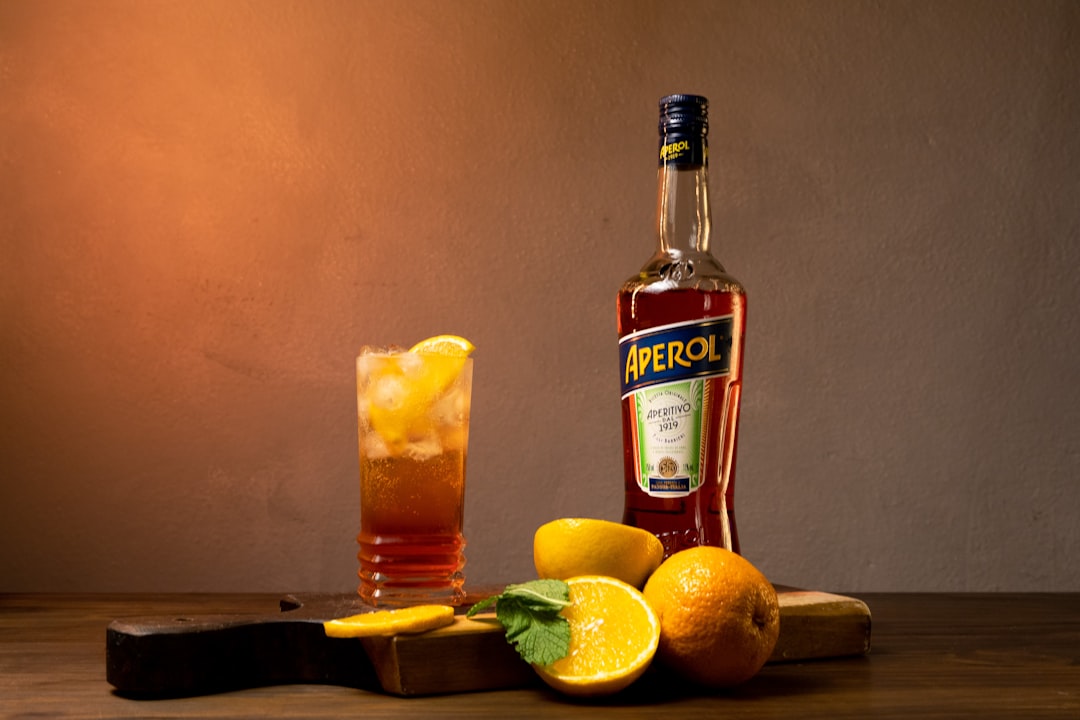 a bottle of alcohol sitting next to some lemons,