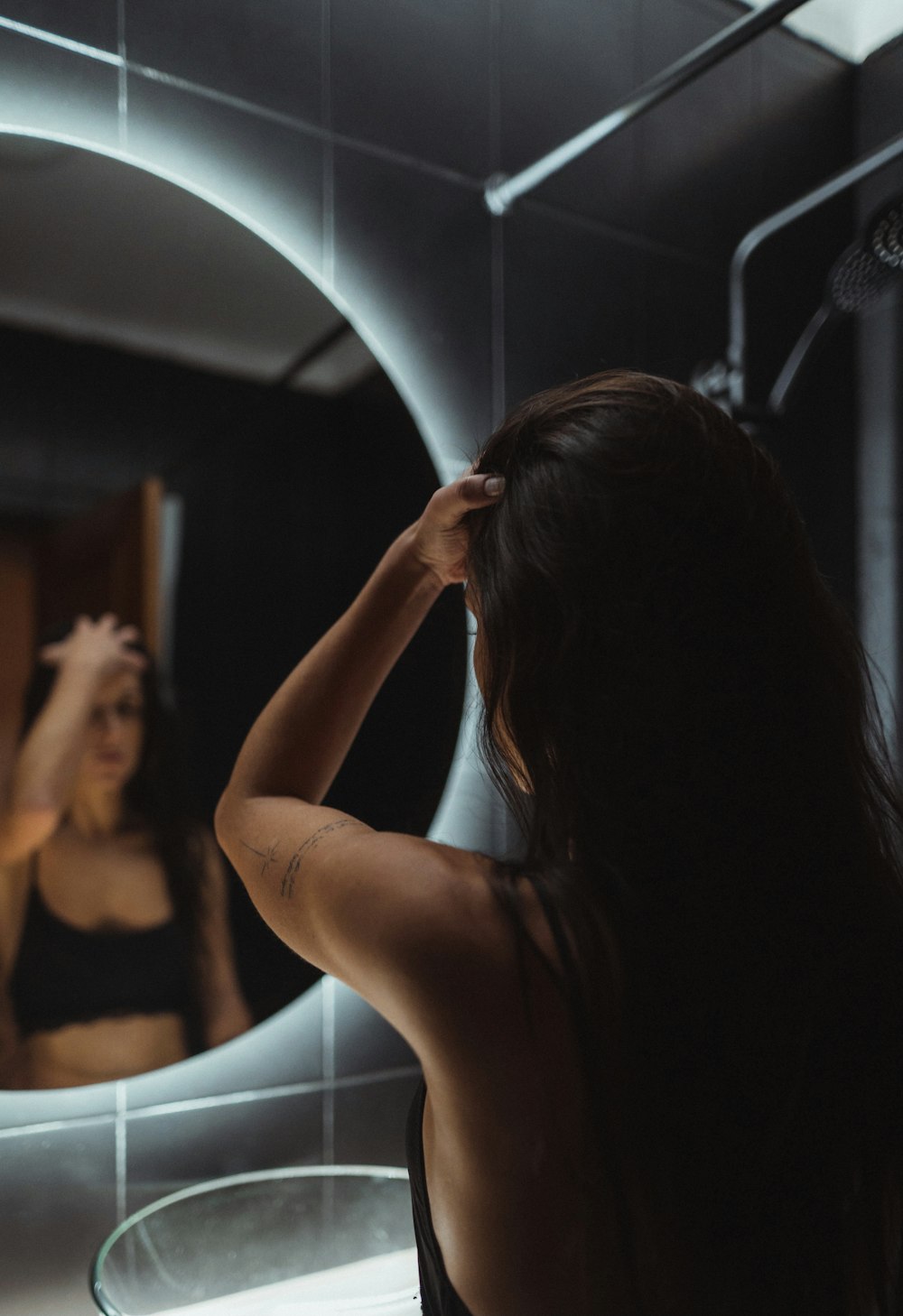 a woman standing in front of a bathroom mirror