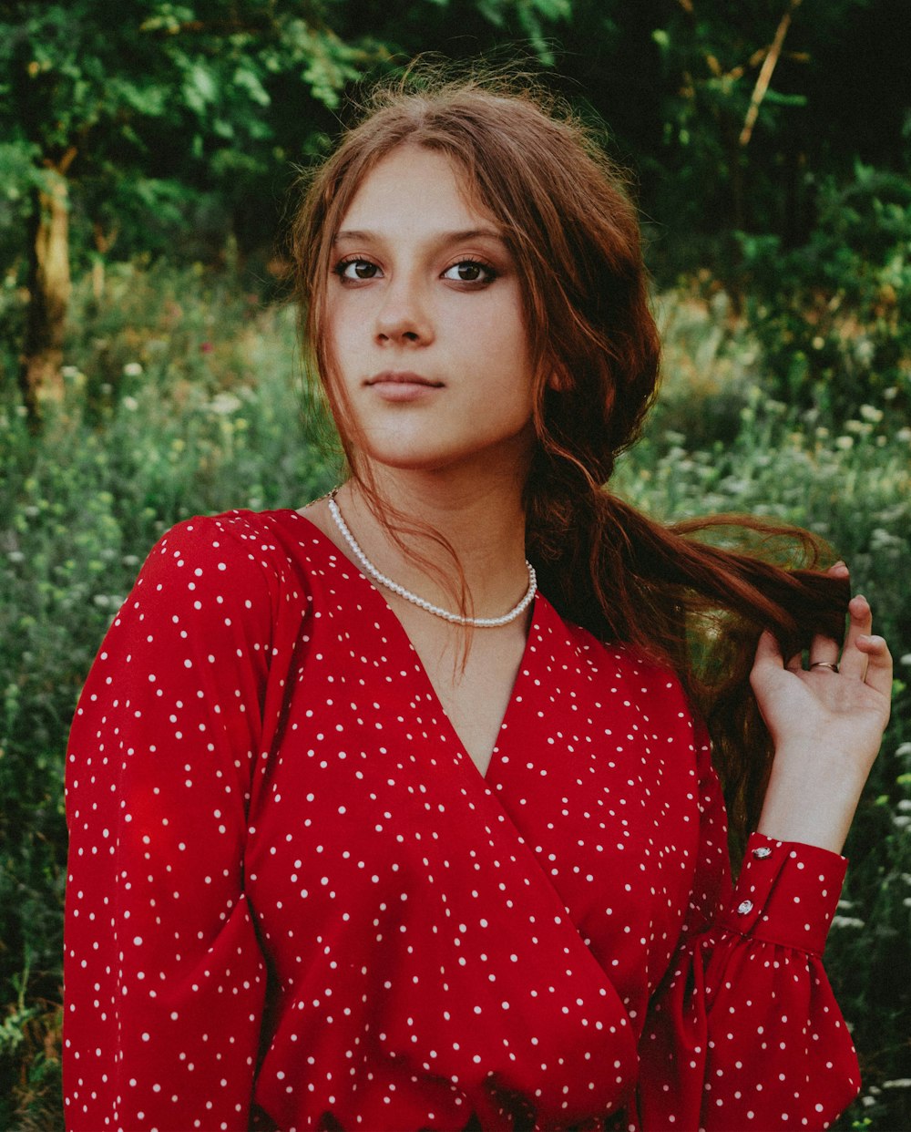 a woman in a red polka dot shirt posing for a picture