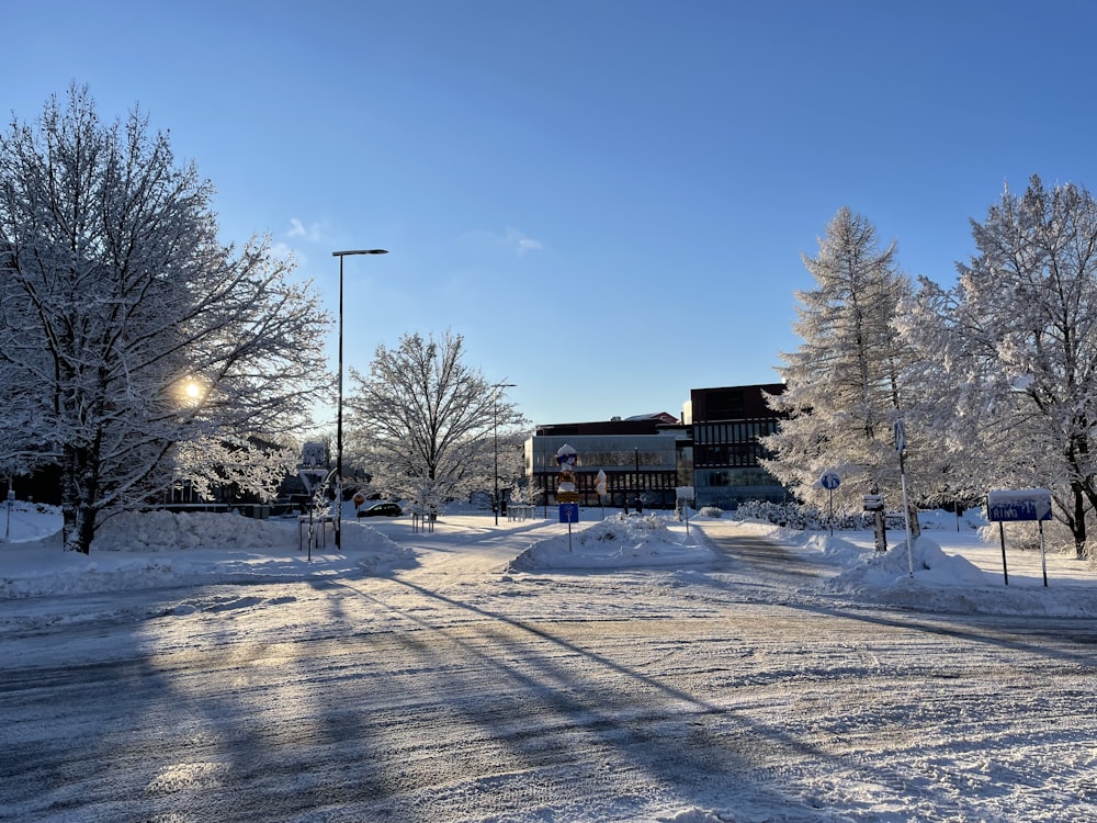 a snowy road with a building in the background