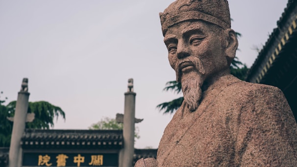 a statue of a man with a beard in front of a building