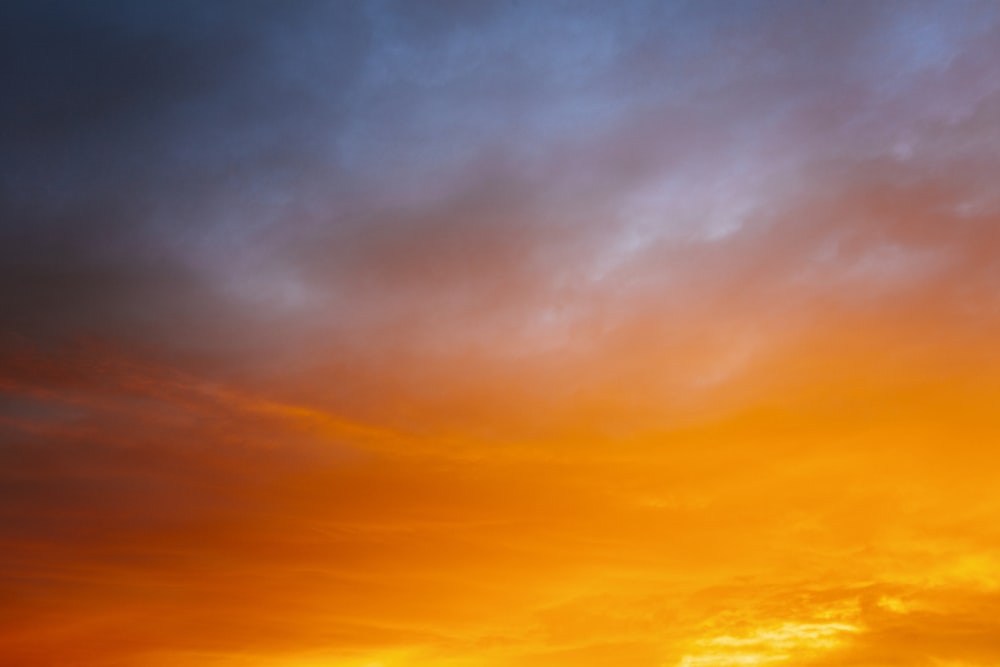 a plane flying in the sky at sunset