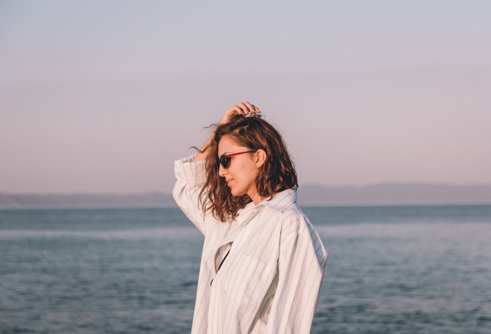 a woman standing on a beach next to the ocean