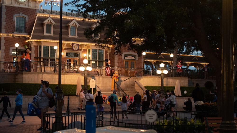 a crowd of people walking around a plaza at night